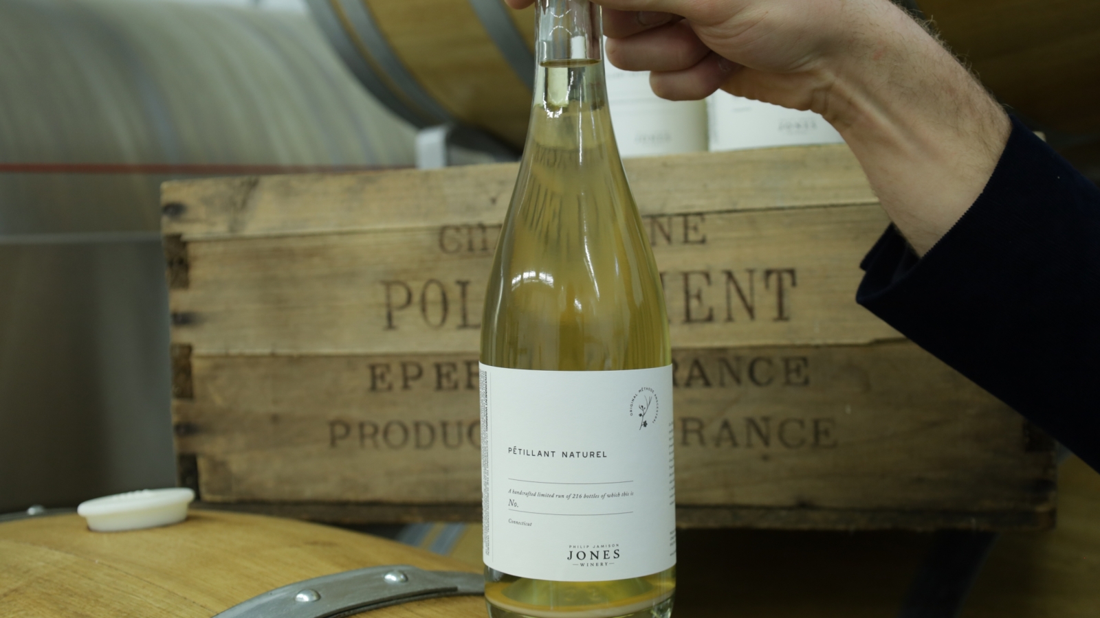 Winemaker holding a bottle of pet nat sparkling wine.