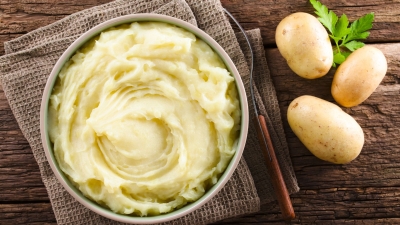 a bowl of Perfect Whipped Potatoes with potatoes on the side