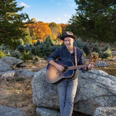 Brian Dolzani sitting on farm rocks in the fall