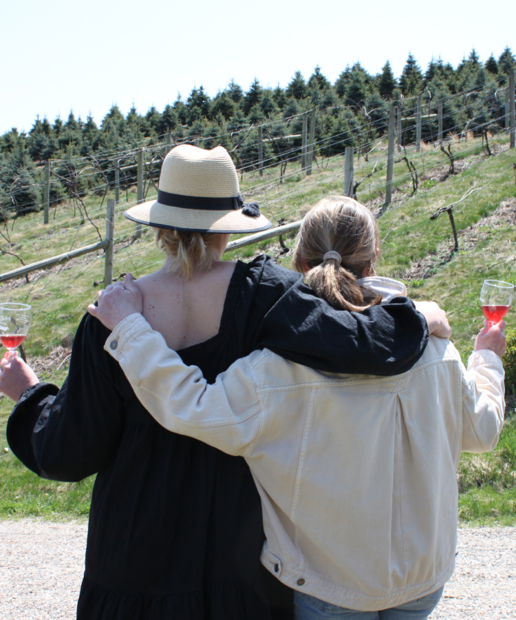 Mother and daughter arm in arm looking at the winery